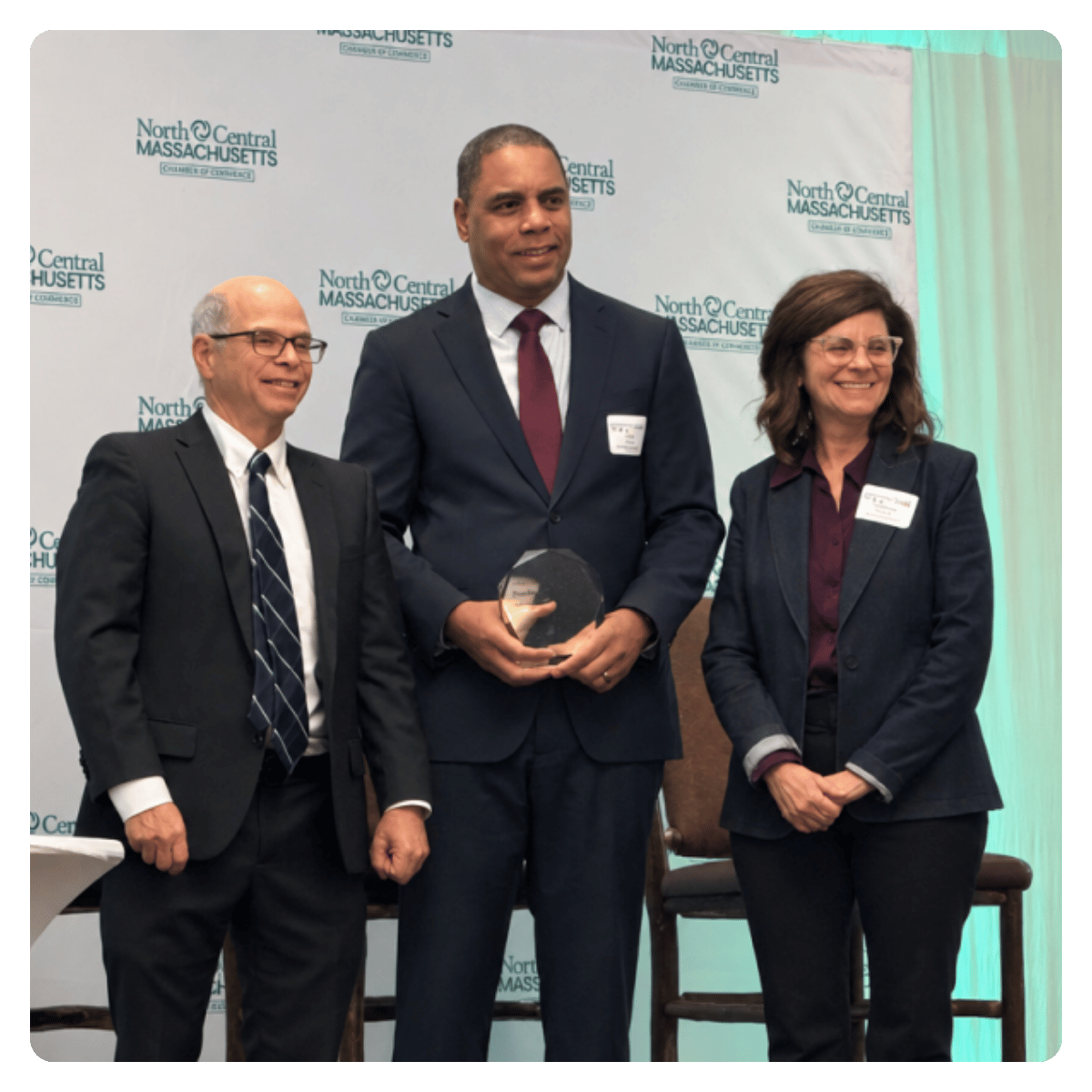 Cleartech Group founder Tony Fields with NewVue Communities Executive Director Marc Dohan and Board President Christina DiRusso on stage at a North Central Massachusetts Chamber of Commerce event.